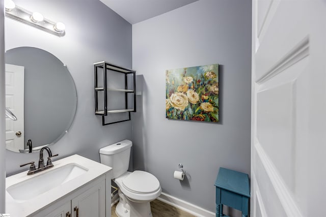 bathroom with vanity, toilet, and wood-type flooring