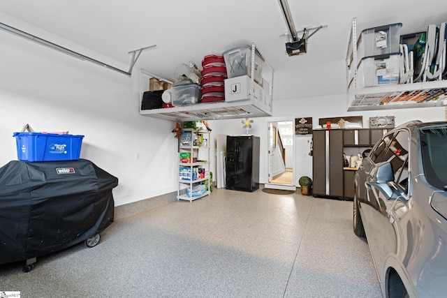 garage featuring black refrigerator with ice dispenser