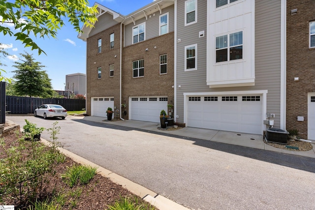 rear view of house with a garage and central AC