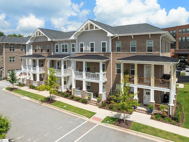 view of property with a porch and a balcony