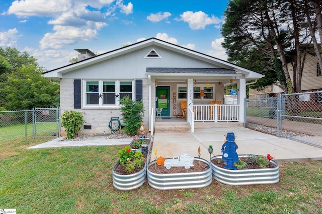 back of house with a porch and a yard