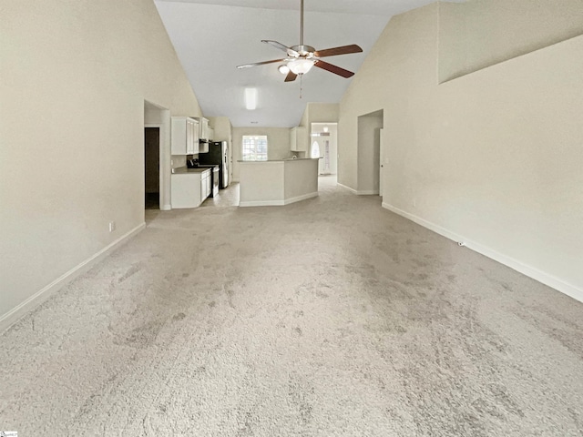 unfurnished living room with ceiling fan, light colored carpet, and high vaulted ceiling