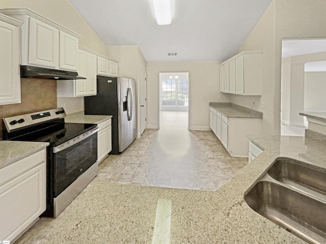 kitchen featuring lofted ceiling, white cabinetry, light stone countertops, and stainless steel appliances