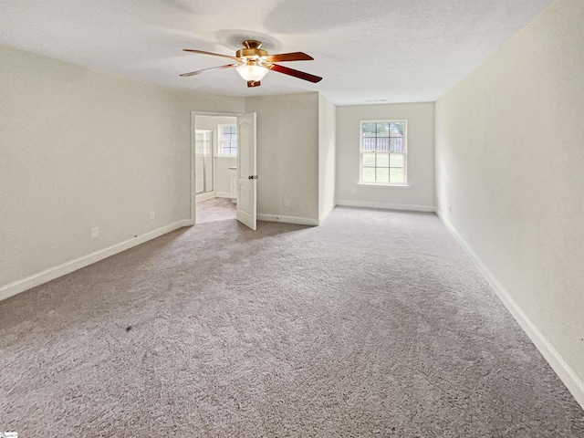 unfurnished room with ceiling fan, light colored carpet, and a textured ceiling