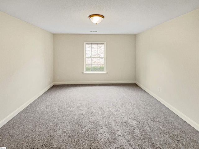 unfurnished room featuring a textured ceiling and carpet floors