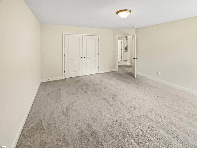 unfurnished bedroom with a closet and carpet flooring