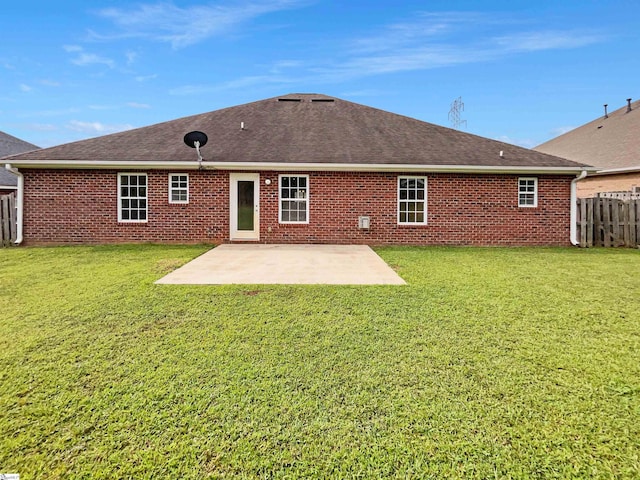 rear view of house featuring a lawn and a patio