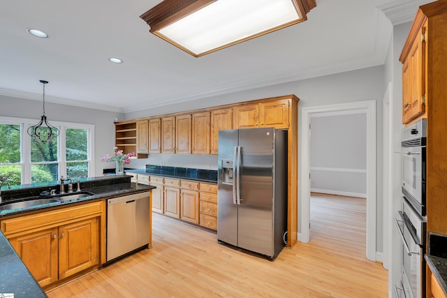 kitchen featuring sink, hanging light fixtures, light wood-type flooring, appliances with stainless steel finishes, and ornamental molding