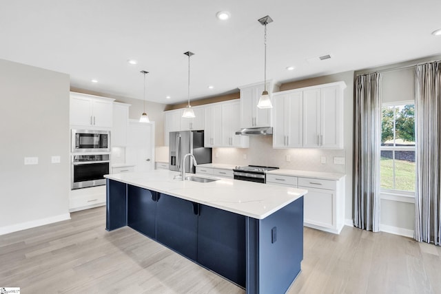 kitchen with a center island with sink, sink, appliances with stainless steel finishes, and white cabinets