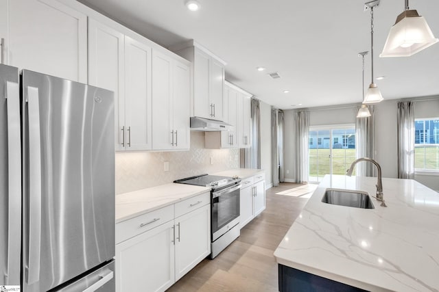 kitchen with light wood-type flooring, pendant lighting, white cabinetry, sink, and appliances with stainless steel finishes