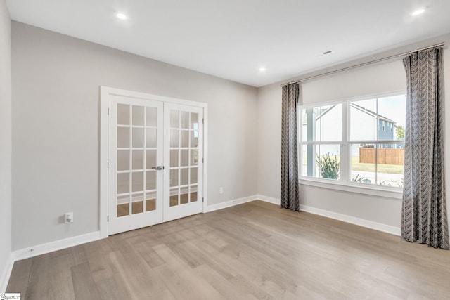 unfurnished room with light wood-type flooring and french doors