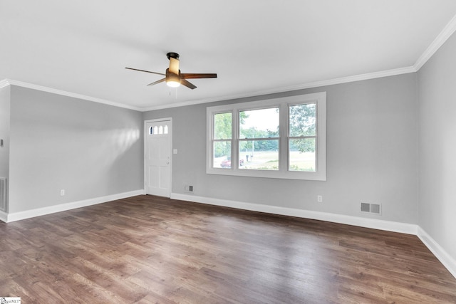 empty room with crown molding, dark wood-type flooring, and ceiling fan