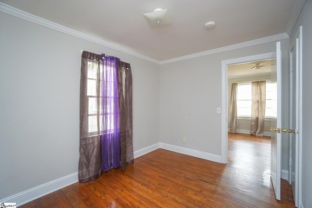 unfurnished room with ornamental molding and hardwood / wood-style flooring