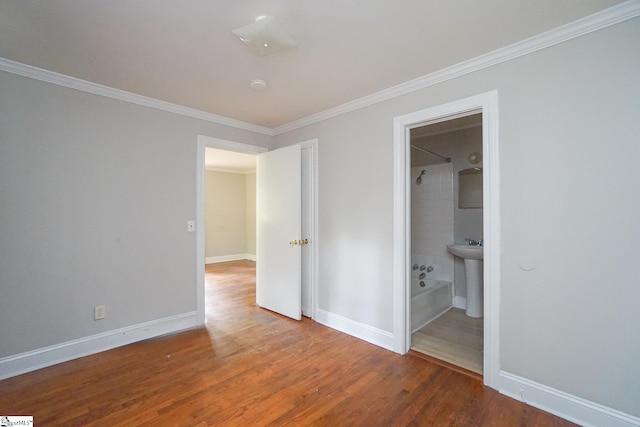 unfurnished bedroom with wood-type flooring, sink, connected bathroom, and ornamental molding