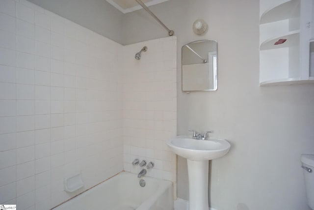 bathroom with tiled shower / bath combo and toilet