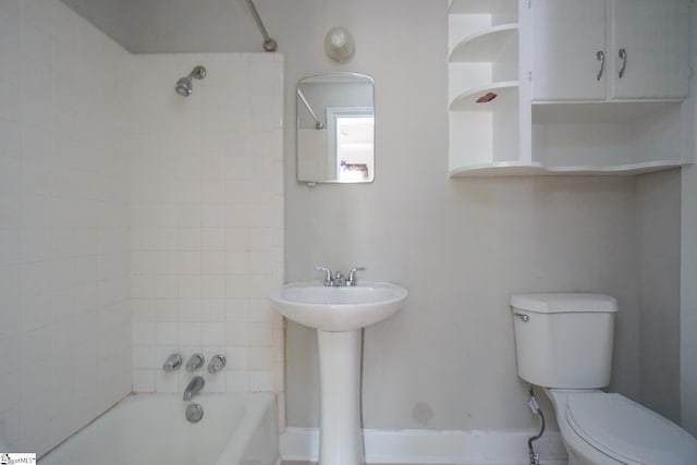 full bathroom with tiled shower / bath combo, toilet, and sink