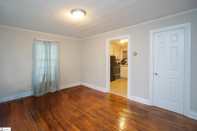 empty room with crown molding and dark hardwood / wood-style flooring