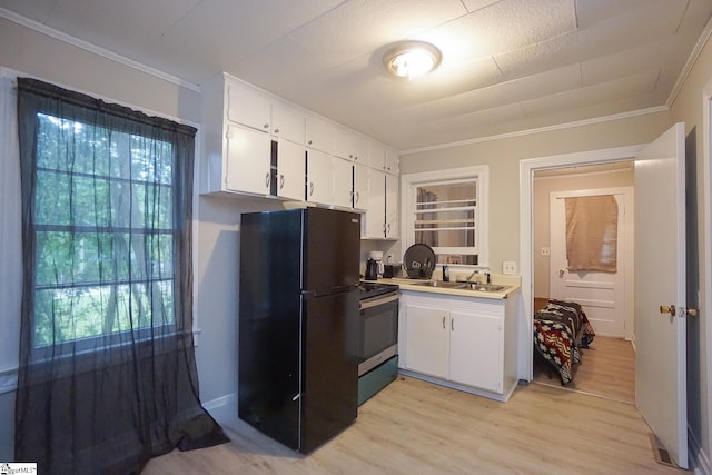 kitchen featuring white cabinets, light wood-type flooring, black refrigerator, and stainless steel electric range