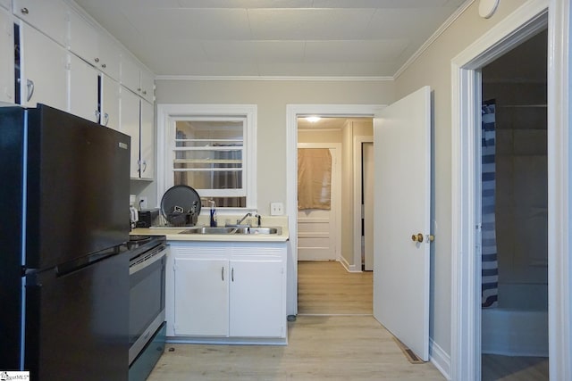 kitchen with light hardwood / wood-style floors, white cabinetry, ornamental molding, stainless steel range with electric stovetop, and black refrigerator