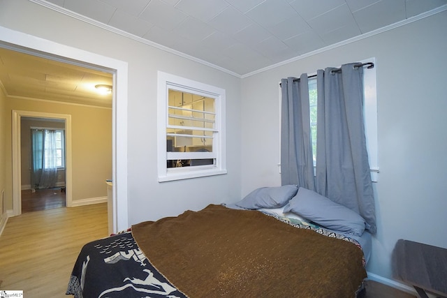 bedroom with light hardwood / wood-style flooring and crown molding