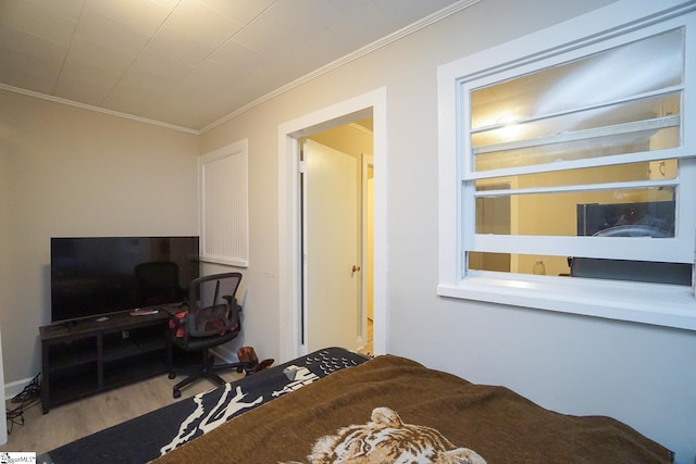 bedroom with wood-type flooring and ornamental molding