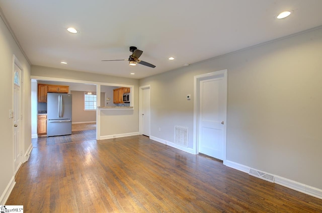 empty room with ceiling fan, ornamental molding, and dark wood-type flooring