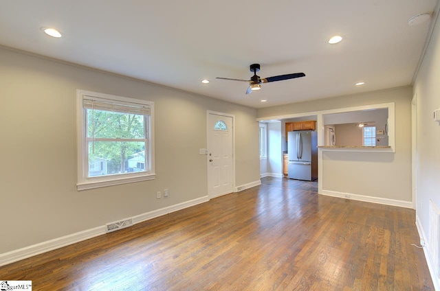 empty room with ornamental molding, ceiling fan, and dark wood-type flooring