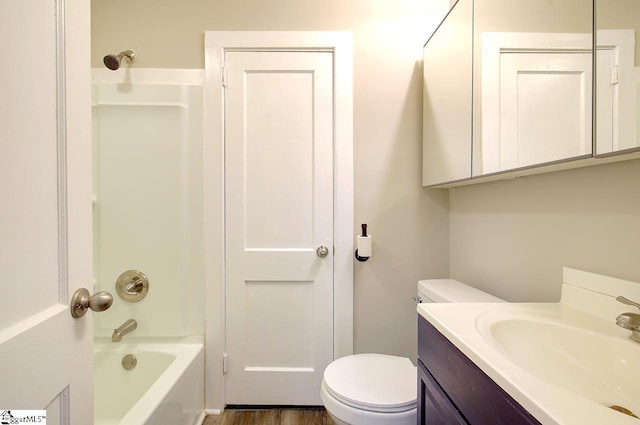 full bathroom featuring hardwood / wood-style floors, washtub / shower combination, vanity, and toilet