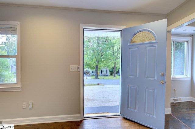 entryway with crown molding, plenty of natural light, and dark hardwood / wood-style flooring