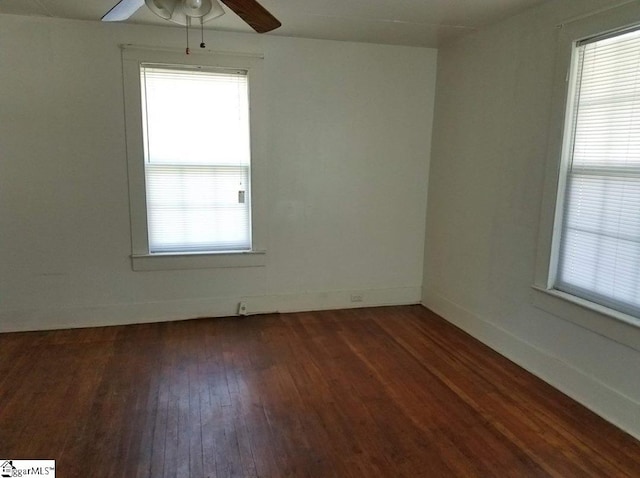 empty room featuring dark hardwood / wood-style flooring, ceiling fan, and a wealth of natural light