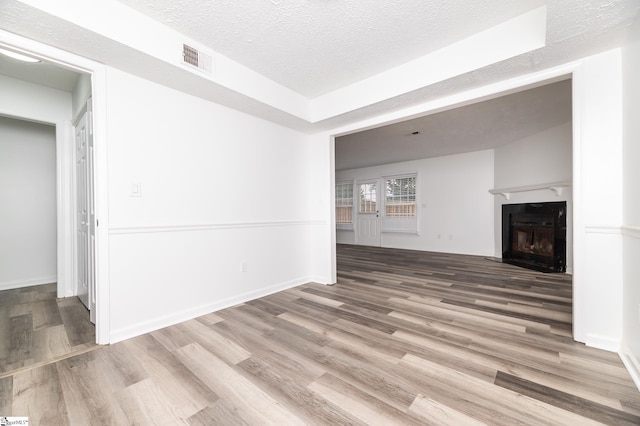 unfurnished living room featuring a textured ceiling and hardwood / wood-style flooring