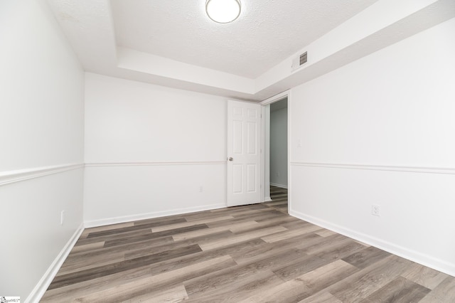 unfurnished room with a textured ceiling and hardwood / wood-style floors