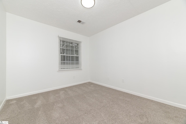 carpeted spare room featuring a textured ceiling