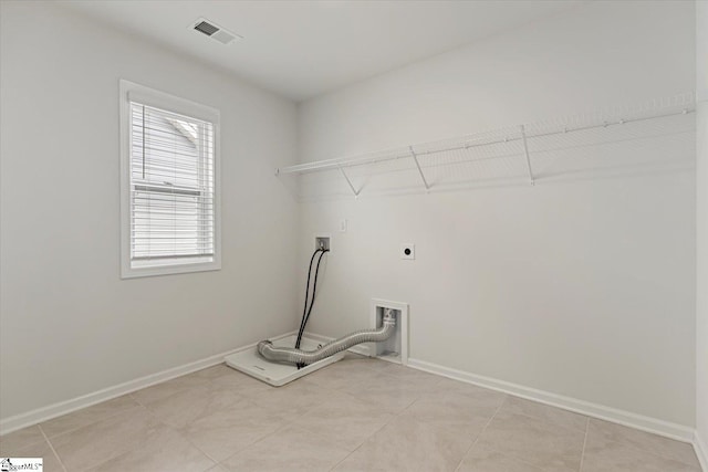 clothes washing area with hookup for a washing machine, light tile patterned floors, and electric dryer hookup