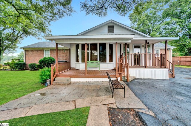 view of front of house featuring covered porch and a front yard