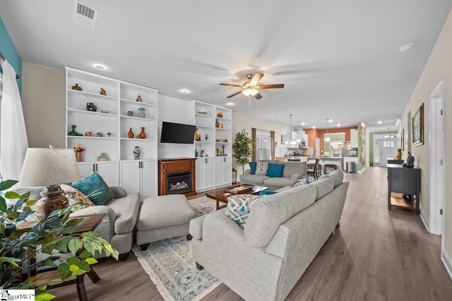 living room featuring light wood-type flooring and ceiling fan