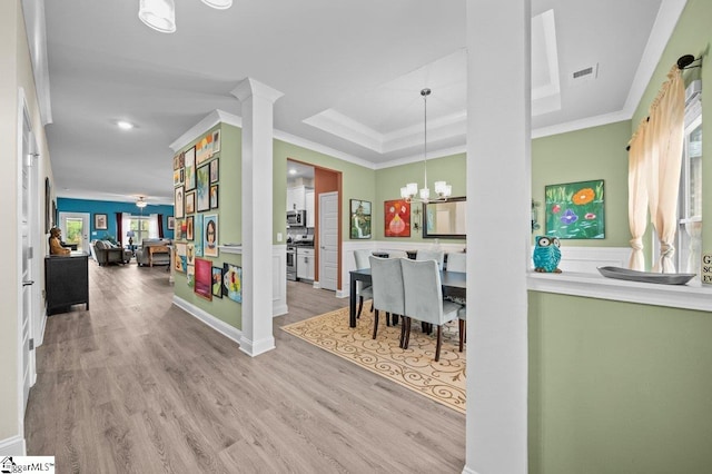 entryway featuring a chandelier, light hardwood / wood-style floors, a healthy amount of sunlight, and crown molding