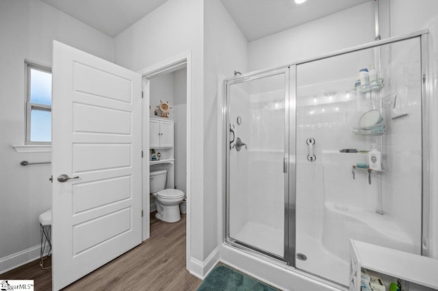 bathroom with an enclosed shower, toilet, and hardwood / wood-style flooring