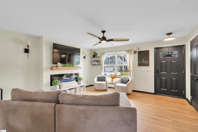 living room featuring ceiling fan and light hardwood / wood-style flooring