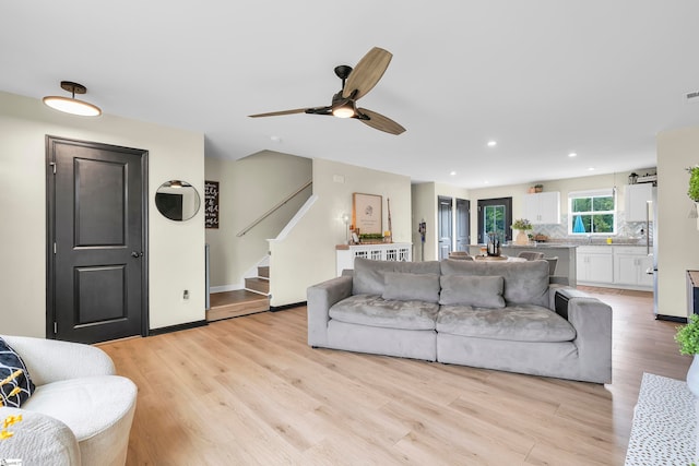 living room featuring light hardwood / wood-style floors and ceiling fan