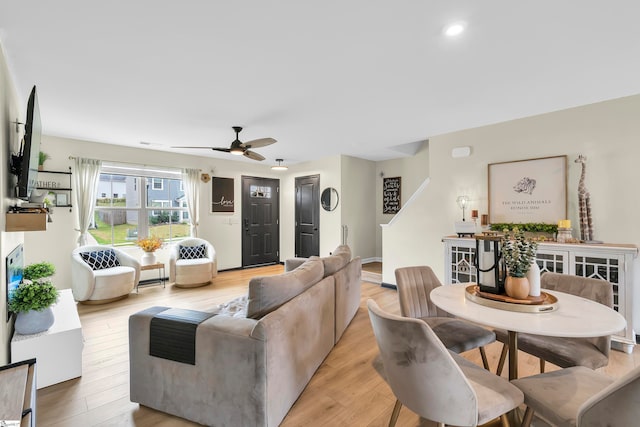 living room with light hardwood / wood-style floors and ceiling fan