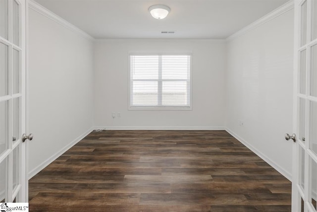 empty room with ornamental molding and dark hardwood / wood-style flooring