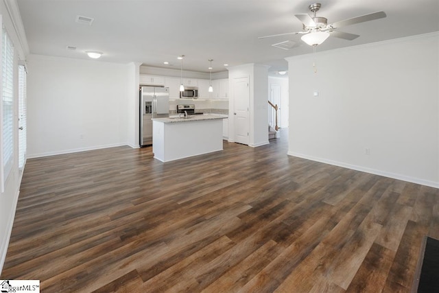 unfurnished living room featuring ornamental molding, ceiling fan, and dark hardwood / wood-style floors