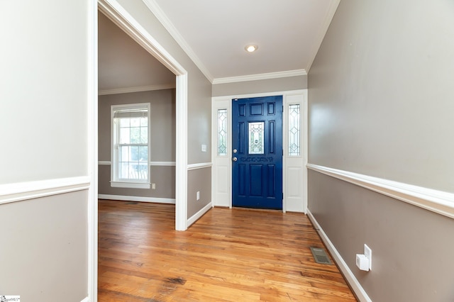 entrance foyer with crown molding and light hardwood / wood-style floors