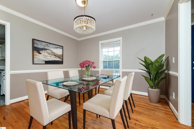 dining room with ornamental molding, a chandelier, and light hardwood / wood-style floors