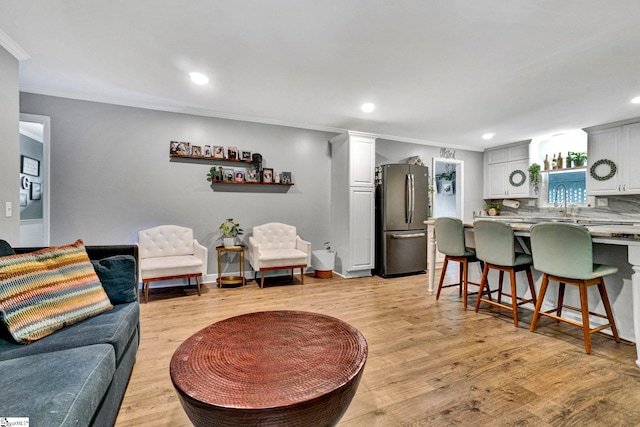 living room with light hardwood / wood-style floors and crown molding