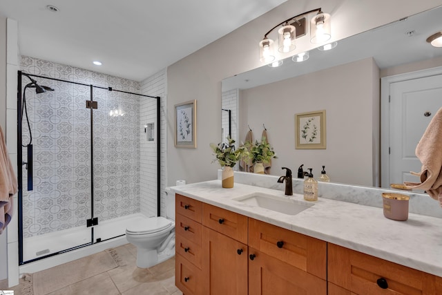 bathroom featuring tile patterned floors, vanity, toilet, and a shower with shower door