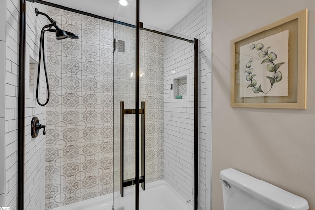 bathroom featuring an enclosed shower and toilet