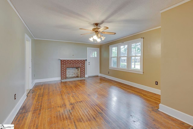 unfurnished living room featuring wood-type flooring, crown molding, and a textured ceiling