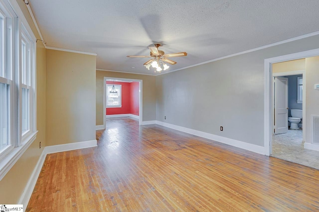 spare room with light hardwood / wood-style floors, ceiling fan, a textured ceiling, and crown molding